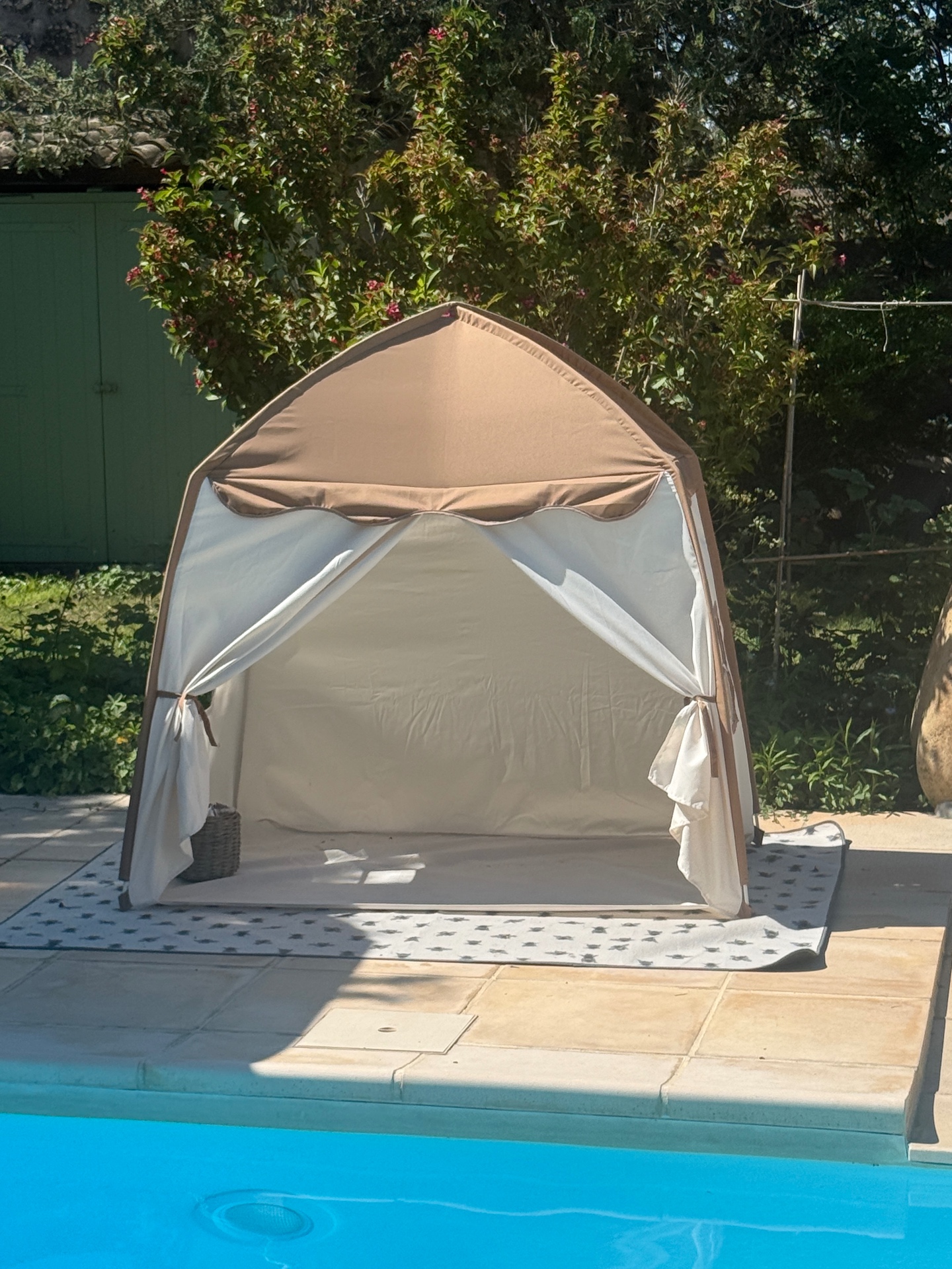 Cabana met linnen gordijnen aan de rand van het zwembad