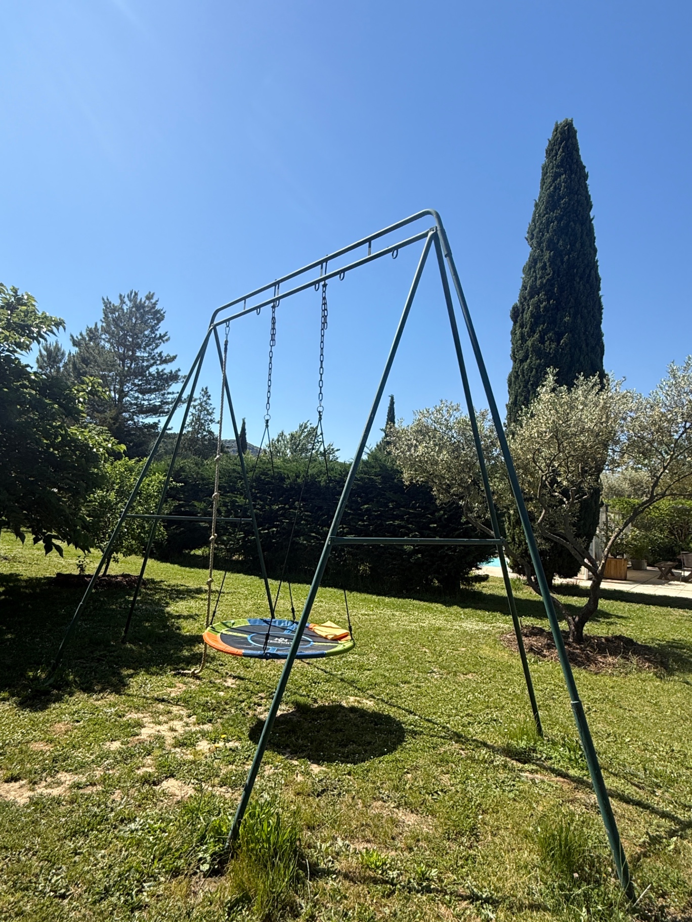 Houten schommel in een schaduwrijke hoek van de tuin